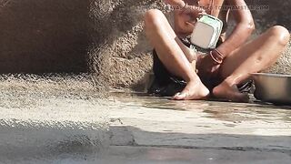 Indian sister-in-law is bathing in the open courtyard of the house, putting a finger in her burrow and rubbing the body, sister-in-law is washing the bathroom.